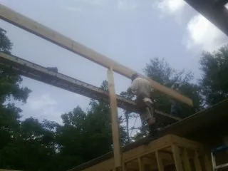 Carpenter setting a ridge beam over a new addition frame — Ice Dam Removal by Roofing Brothers in Cobb