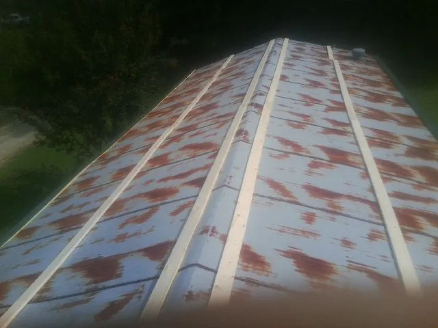 Rusted metal roof panels with new wood purlins before replacement — Storm Damage Roof Repair in Cobb by Roofing Brothers