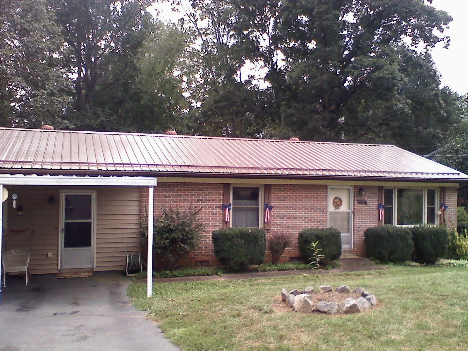 Bronze metal roof and carport on a brick ranch home — Roof Repair work by our crew in Cobb