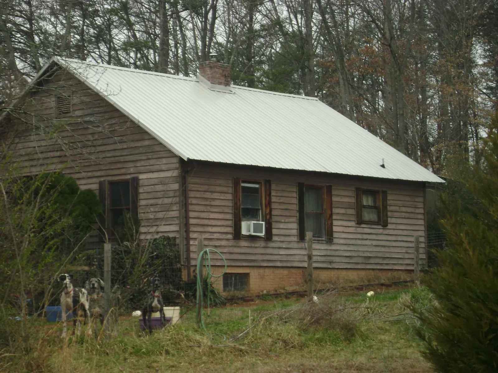 White metal roof on an old wood sided farmhouse, from a Metal Roof Installation job in Cobb